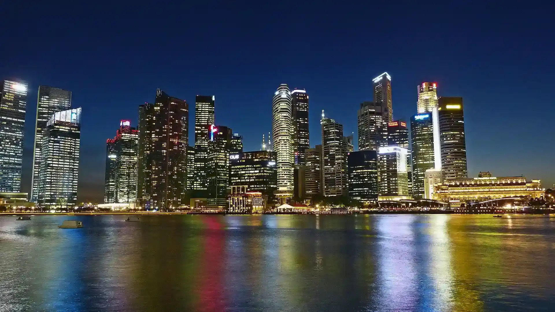 Skyscraper at night with water infront of them